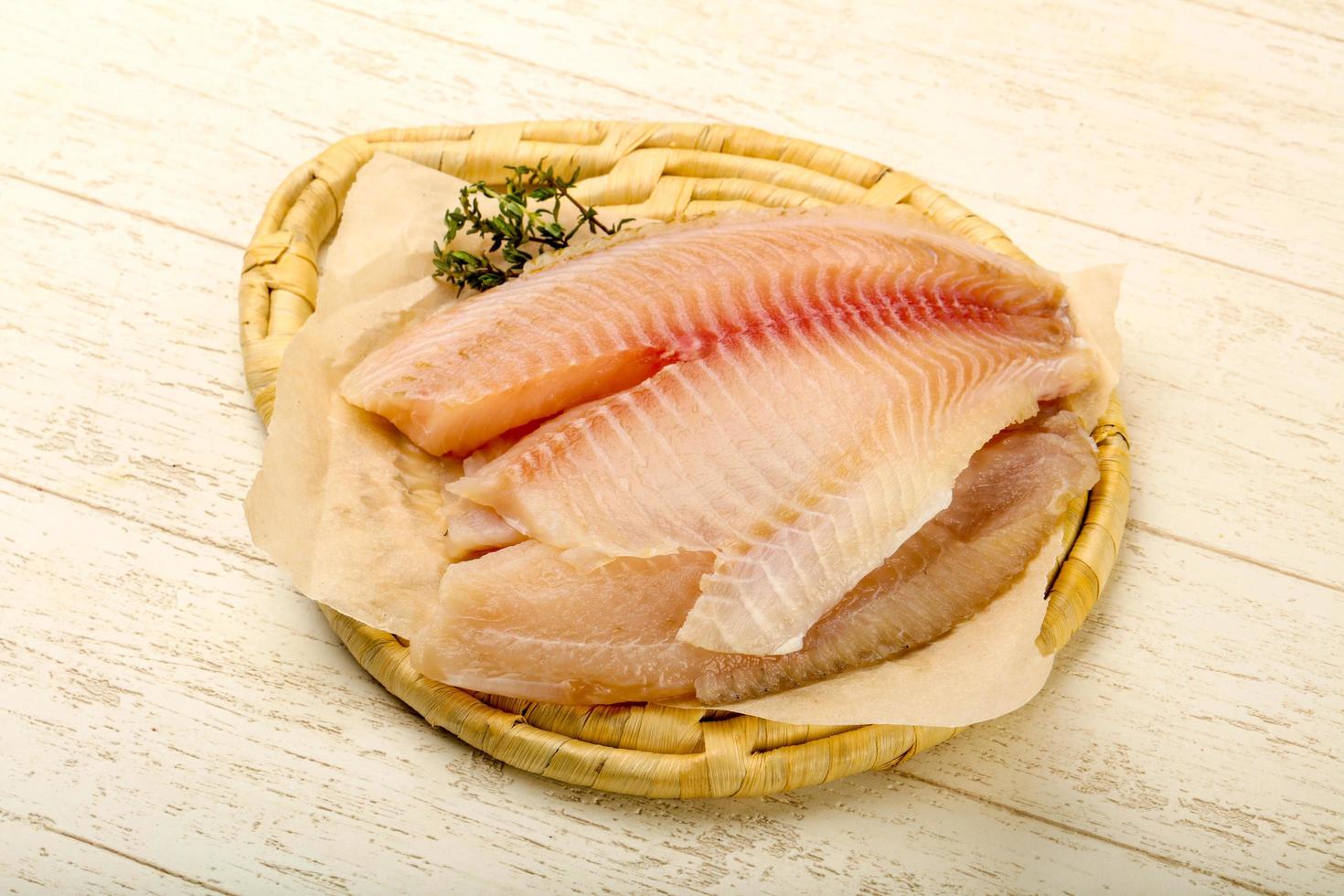 tilapia filet Aan houten bord en houten achtergrond foto