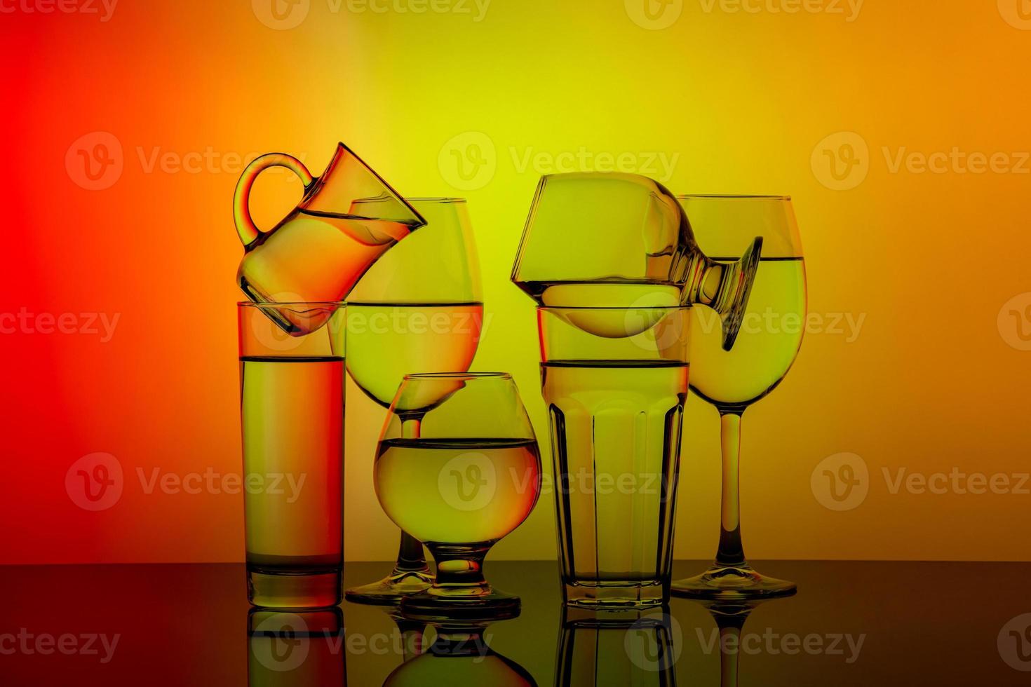 sommige bril voor verschillend drankjes gestapeld Aan een kleurrijk achtergrond foto