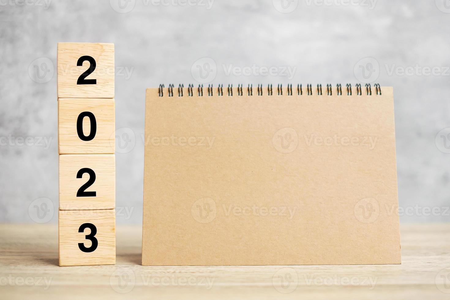 2023 gelukkig nieuwjaar met blanco notitieboekje en houten nummer. aftellen, resolutie, doelen, plan, actie en missieconcept foto