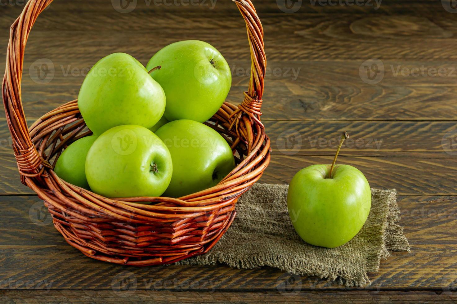 biologisch oma Smith appels in een rieten mand Aan houten tafel foto