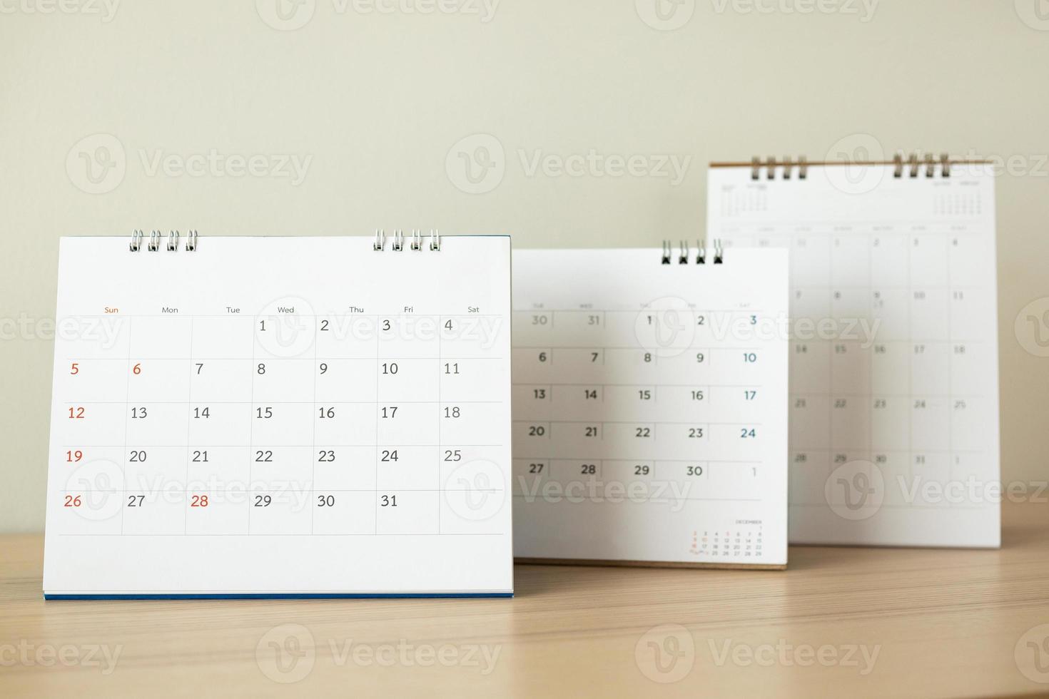 kalender bladzijde dichtbij omhoog Aan hout tafel met wit muur achtergrond foto