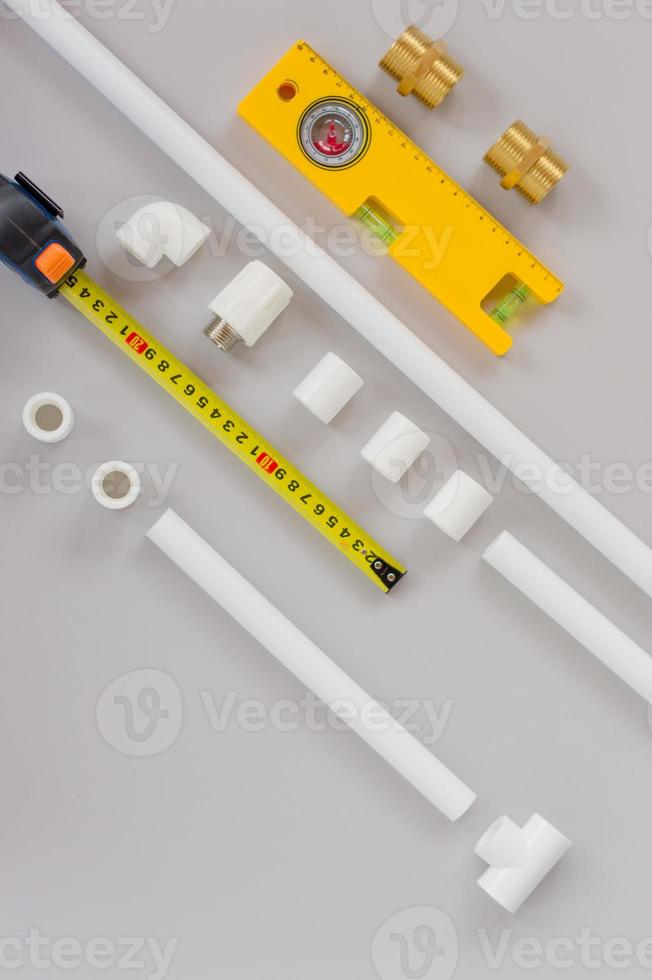 plastic pijpen voor de water systeem, heerser en meten niveau Aan grijs achtergrond. reparatie onderhoud, uitverkoop, online. vlak leggen. kopiëren ruimte. foto