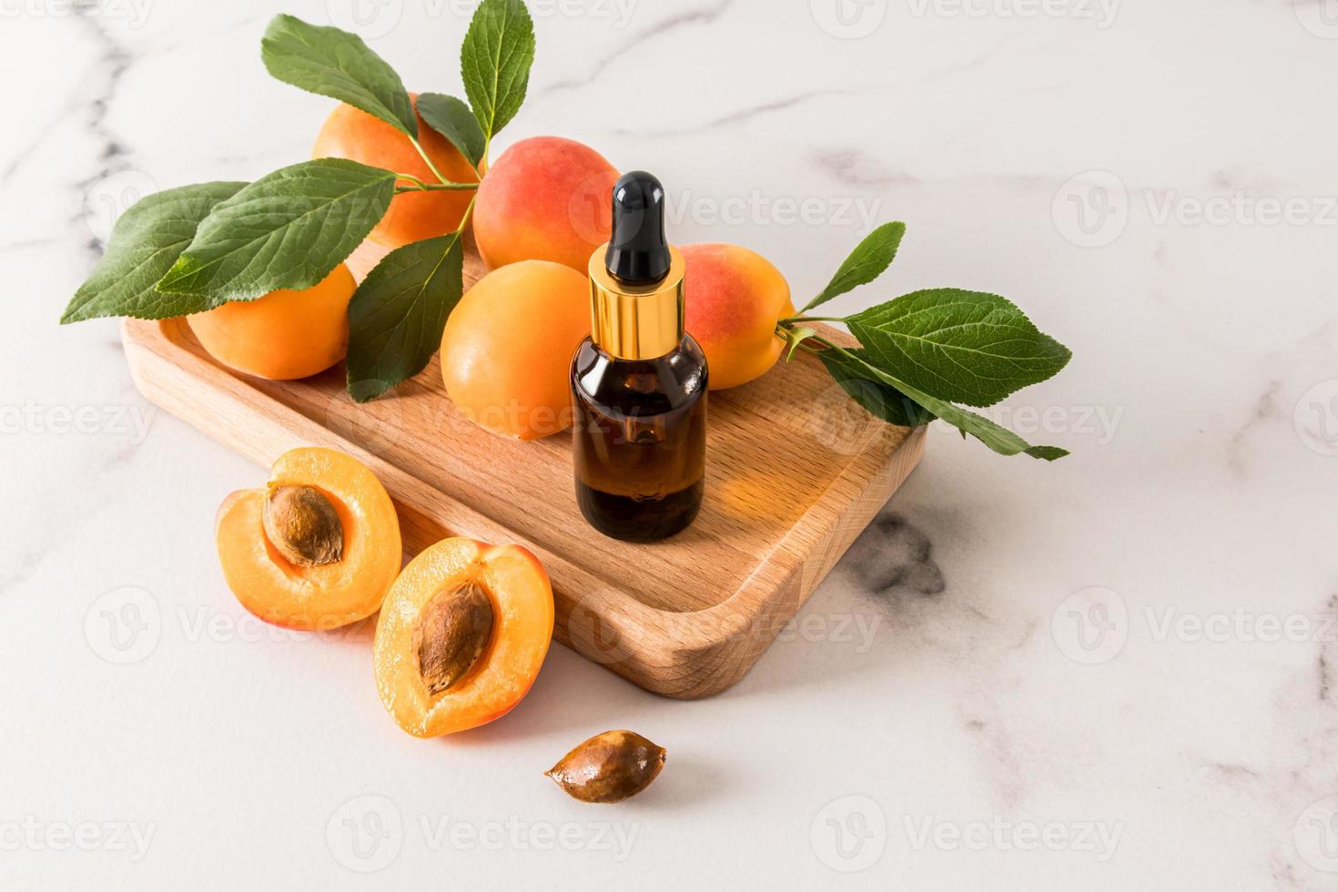 serum voor gelaats huid zorg gebaseerd Aan abrikoos zaad olie in een fles met een pipet Aan een houten dienblad. diep restauratie van de huid. rustgevend zorg. foto