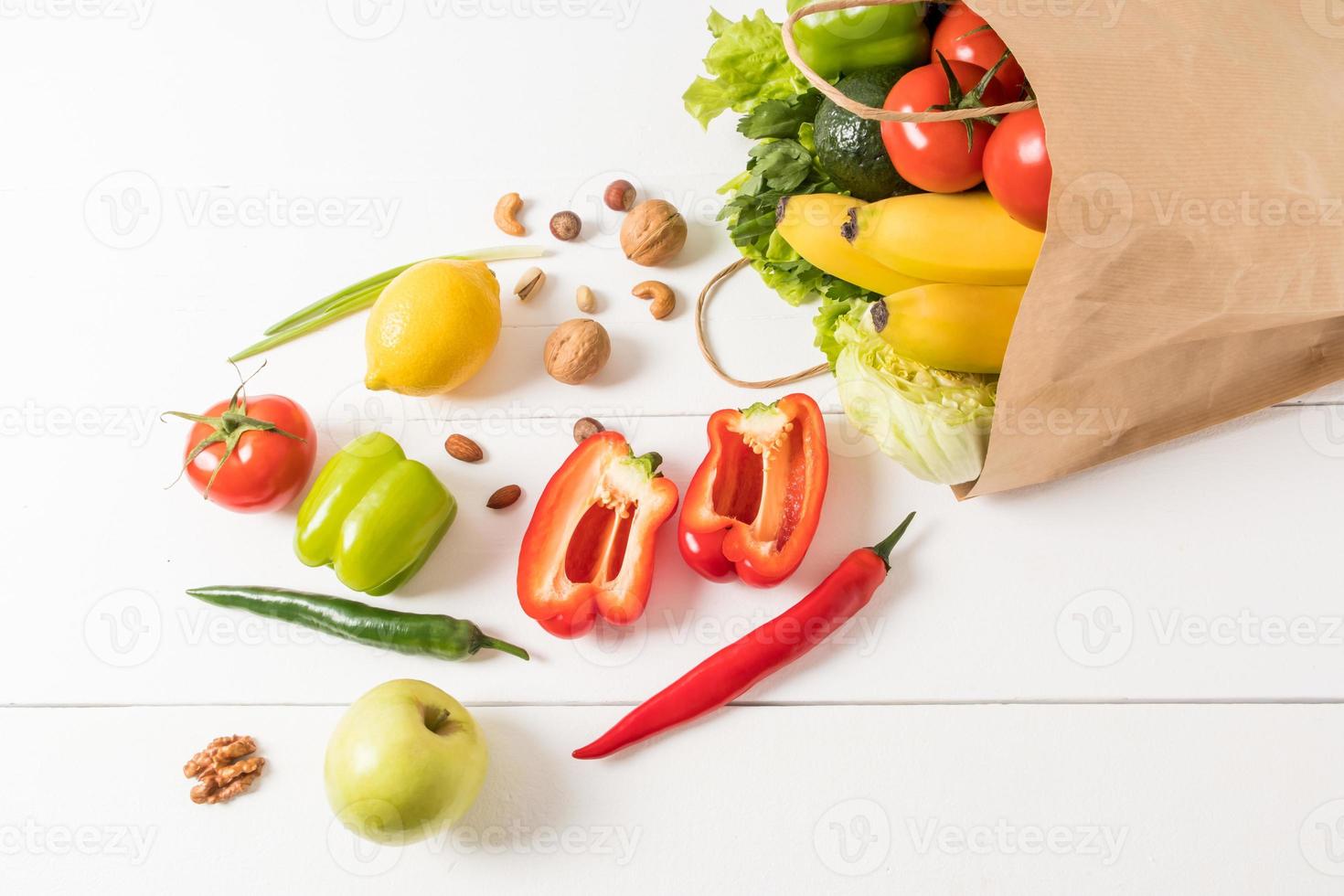 gezond veganistisch voedsel in een ambacht papier zak Aan een wit houten achtergrond. de concept van de Rechtsaf keuze van producten in de supermarkt. foto