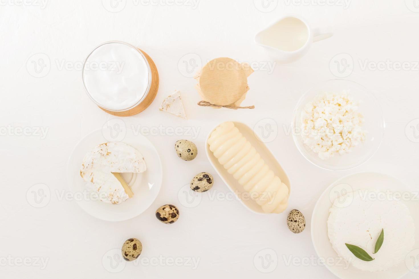 een assortiment van zuivel producten Aan een wit tafel. verzuren room, kaas, huisje kaas, melk, yoghurt. melk den. zuivel eetpatroon. top uitzicht.plat leggen. foto