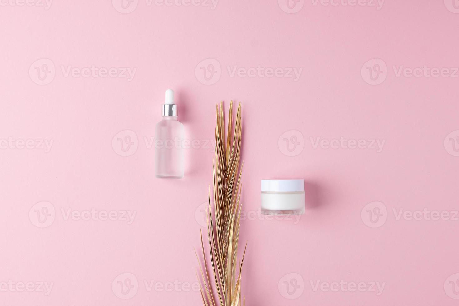 minimaal samenstelling met kunstmatig huid zorg producten en palm blad Aan roze achtergrond. vlak leggen, kopiëren ruimte foto