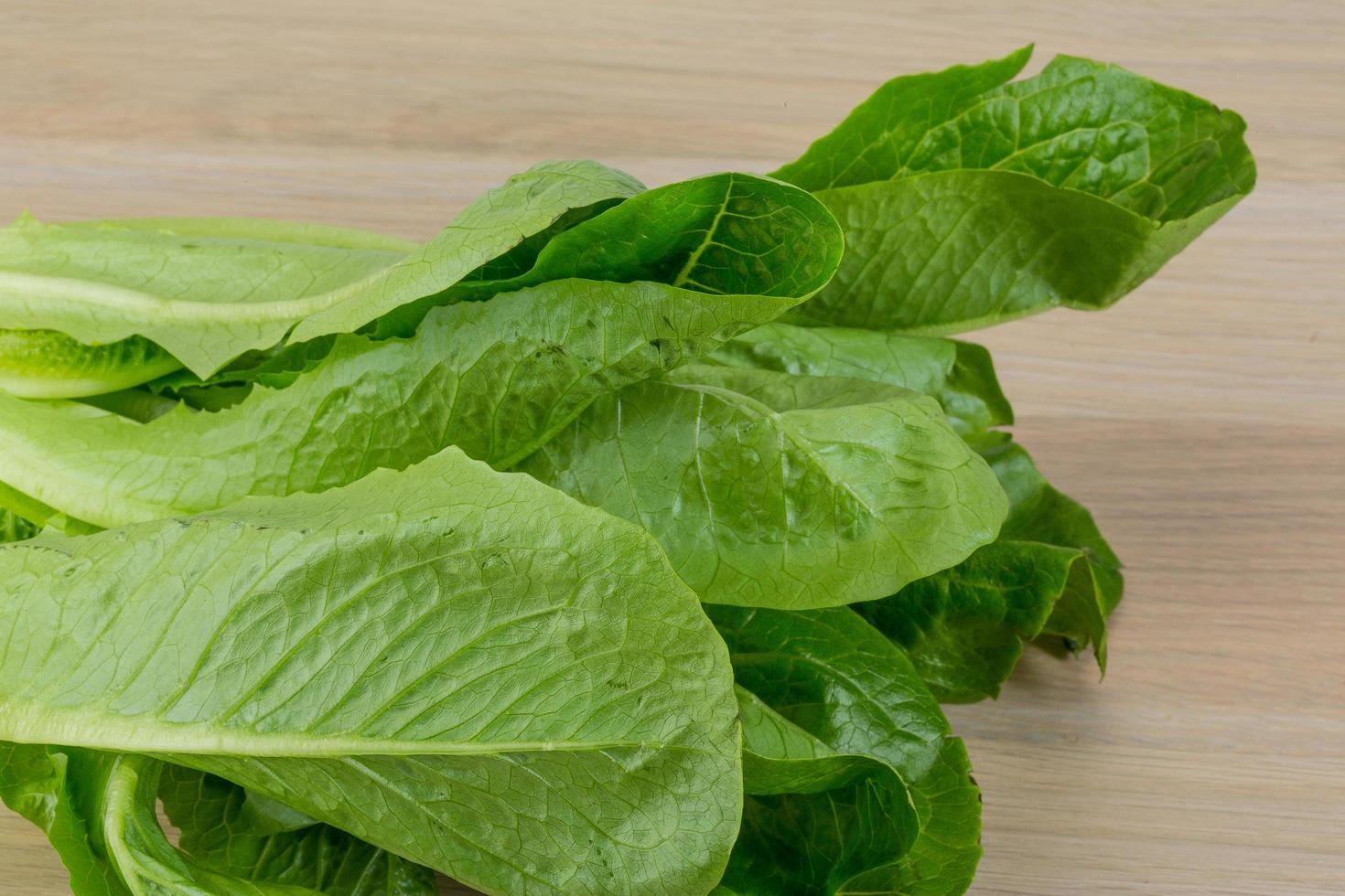 romano salade Aan houten achtergrond foto