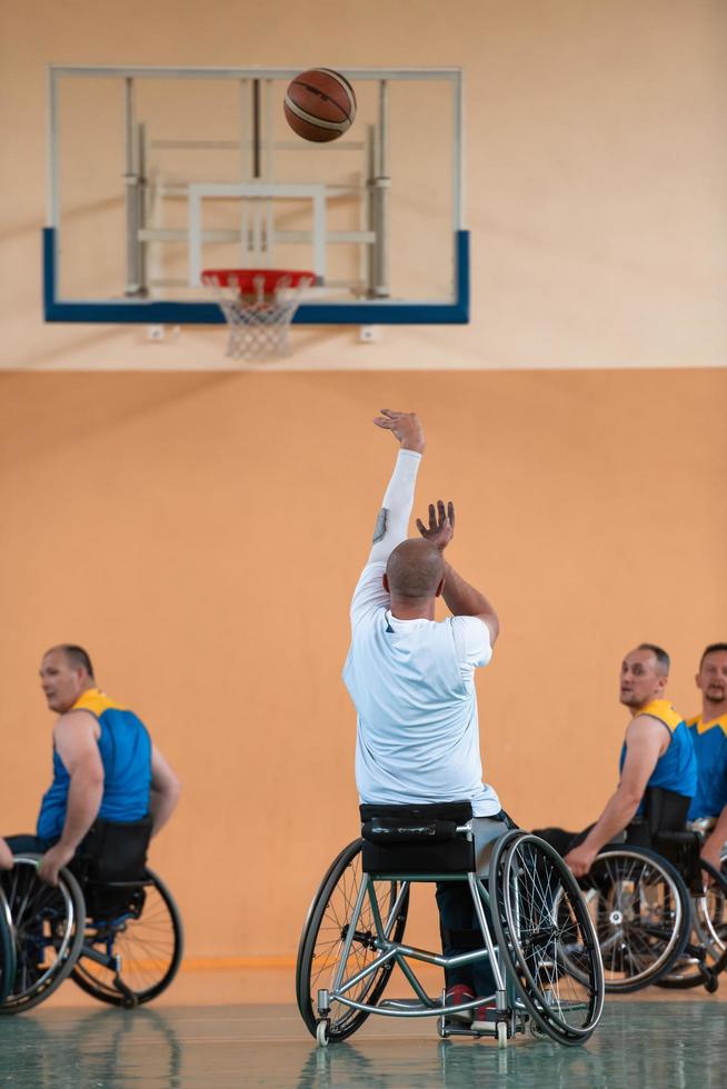 gehandicapt oorlog veteranen gemengd ras en leeftijd basketbal teams in rolstoelen spelen een opleiding bij elkaar passen in een sport- Sportschool hal. gehandicapten mensen revalidatie en inclusie concept foto