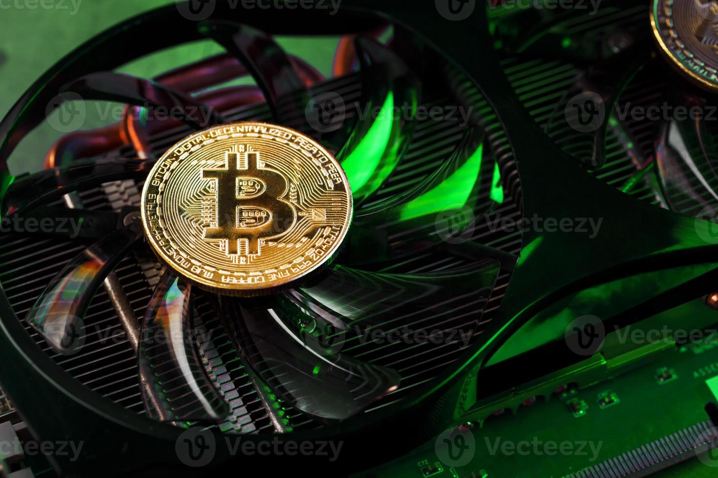 Aan de krachtig fans van de video kaart Daar zijn munten van de bitcoin cryptogeld met een groen achtergrondverlichting foto