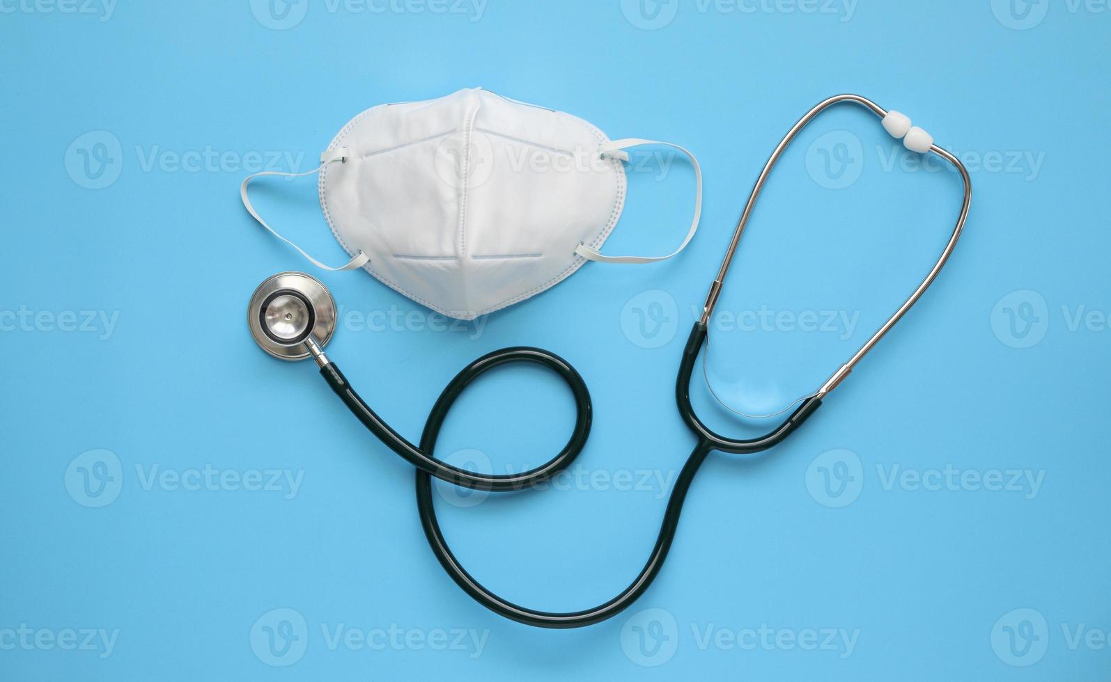 stethoscoop medisch uitrusting met kn95 gezicht masker Aan blauw achtergrond covid-19 coronavirus het voorkomen gezondheidszorg concept foto