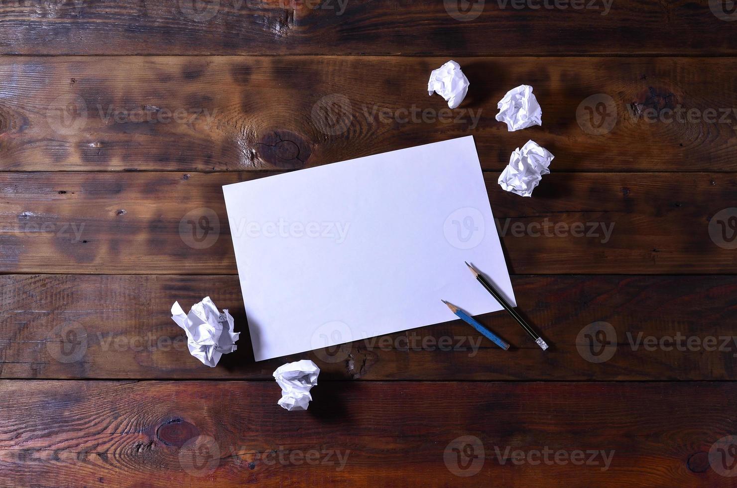 foto van een schoon wit blanco vel van papier liggen Aan een bruin houten achtergrond. genoeg van ruimte voor tekst