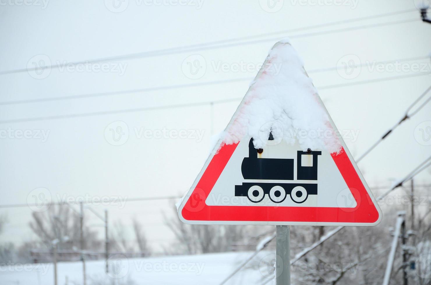 spoorweg kruispunt zonder barrière. een weg teken beeltenis een oud zwart locomotief, gelegen in een rood driehoek foto