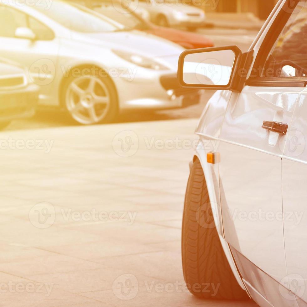 diagonaal visie van een wit glanzend auto dat staat Aan een plein van grijs tegels foto