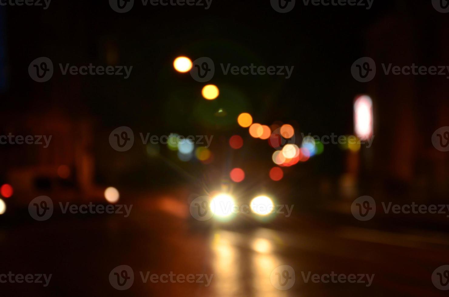 wazig nacht tafereel van verkeer Aan de rijweg. onscherp beeld van auto's op reis met lichtgevend koplampen. bokeh kunst foto