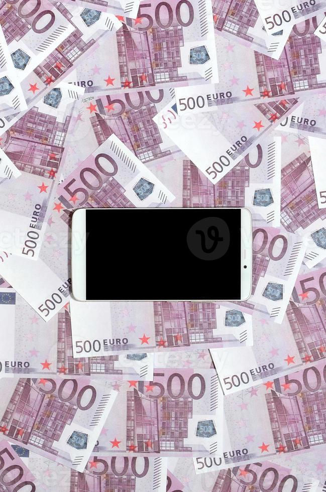 Purper 500 euro geld rekeningen en een smartphone met zwart scherm. kopiëren ruimte. de concept van online bankieren, geld beheer en boodschappen doen met modern technologie foto