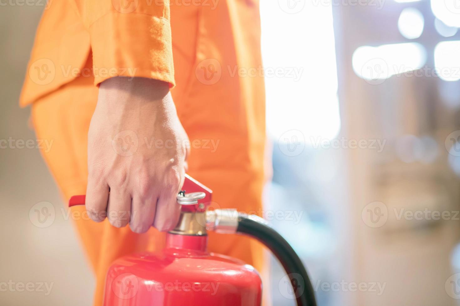 focus Aan de brand brandblusser, de Mens gedragen de brand brandblusser naar zetten uit de brand in de gebouw. foto