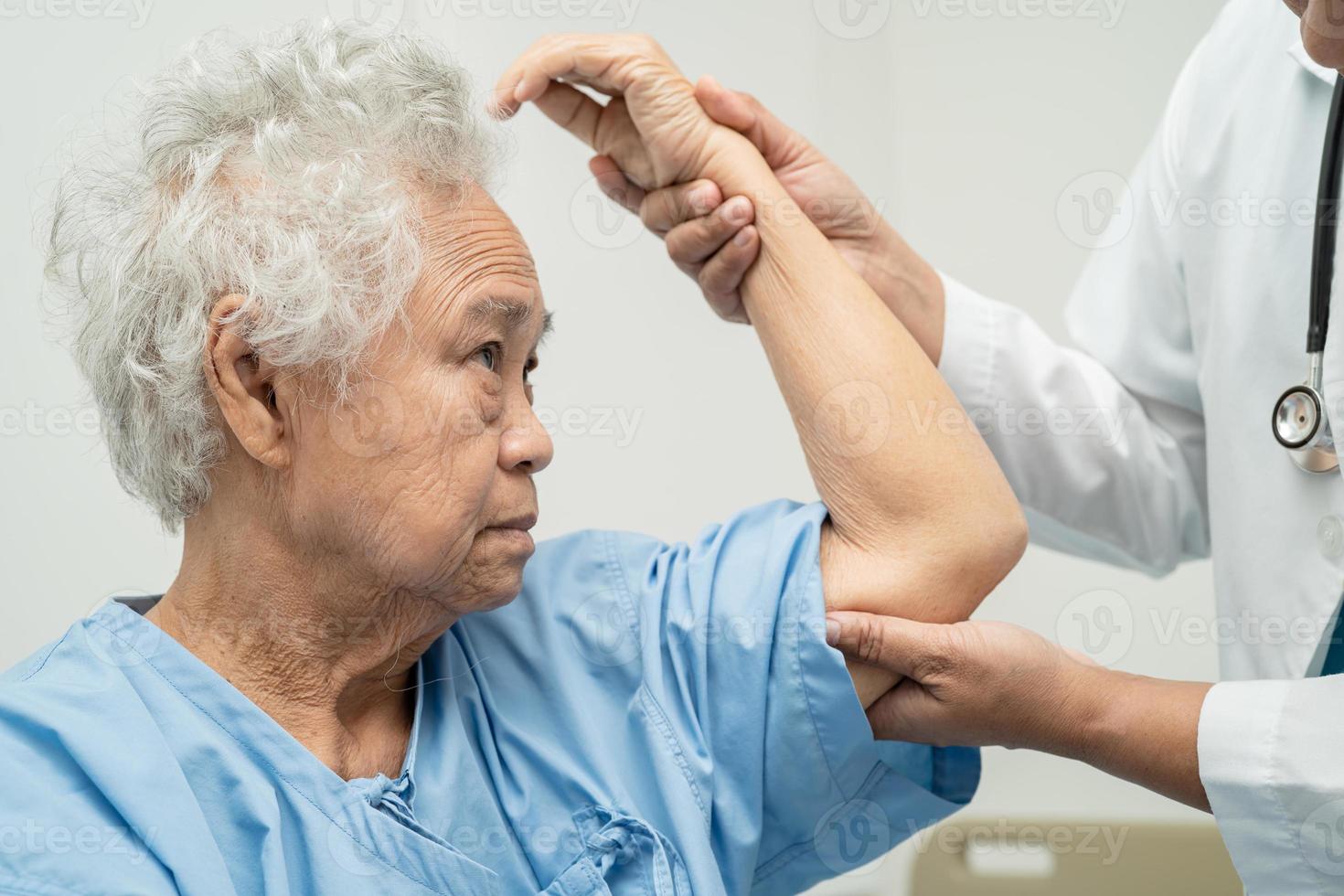 Aziatische senior of oudere oude dame vrouw patiënt voelt pijn haar elleboog op bed in verpleegafdeling, gezond sterk medisch concept. foto