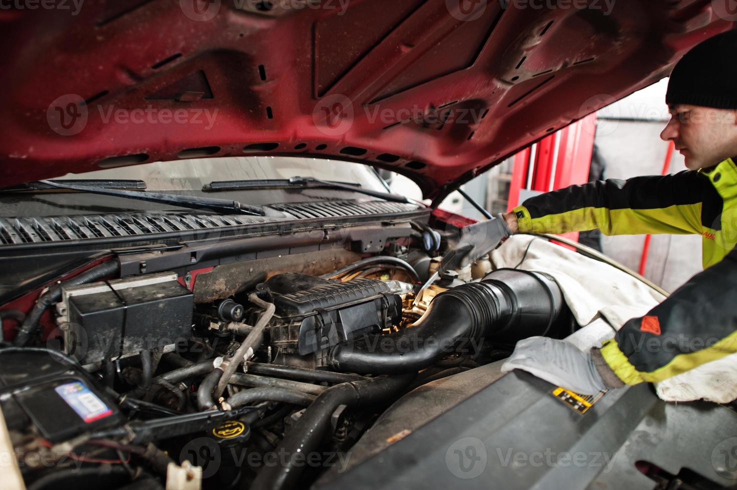 automonteur stelt Amerikaanse SUV-auto in voor diagnostiek en configuratie in werkplaatstankstation.. foto