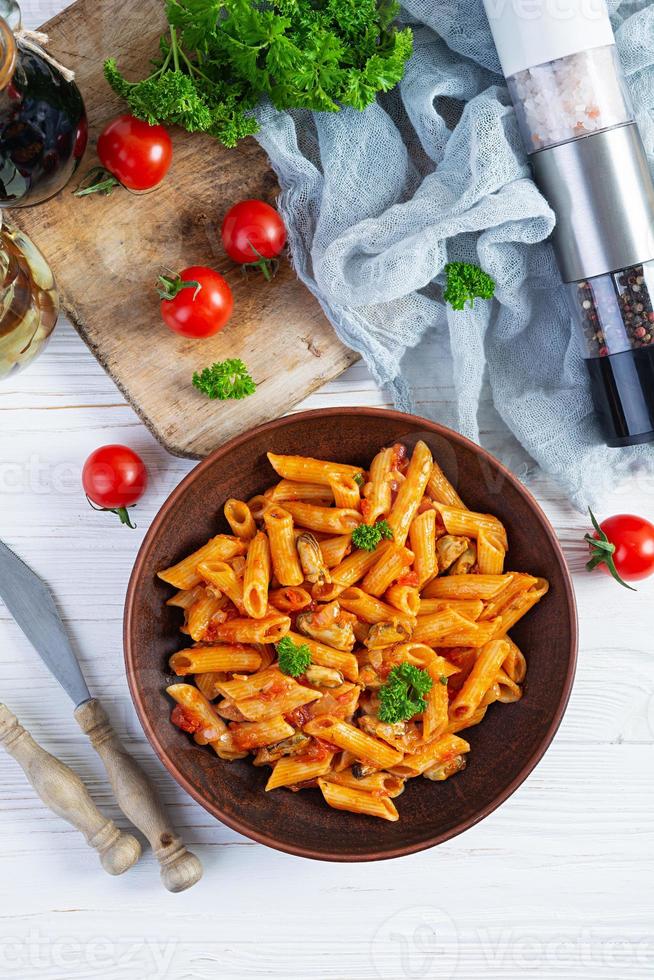 pasta penne in Marinara saus met mosselen, ui en peterselie. klassiek Italiaans pasta penne. top visie foto