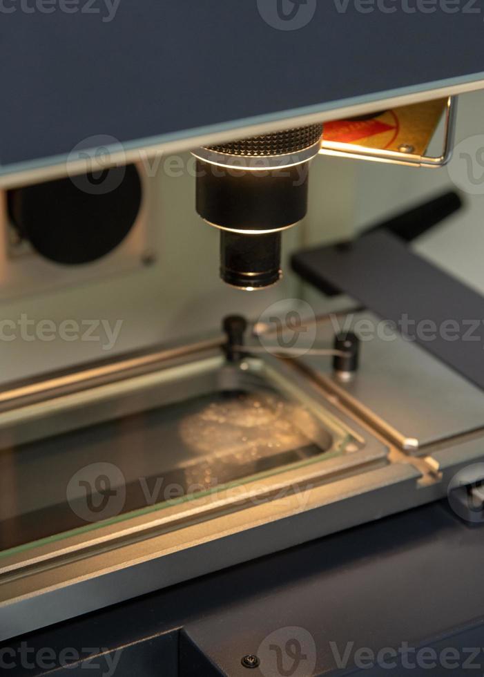 een verticaal detailopname schot van een verlichte microscoop Bij een medisch productie magazijn foto