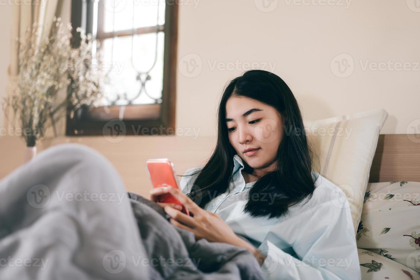 jong volwassen single vrouw gebruik makend van smartphone in de morgen voor sociaal bericht app babbelen met vriend foto