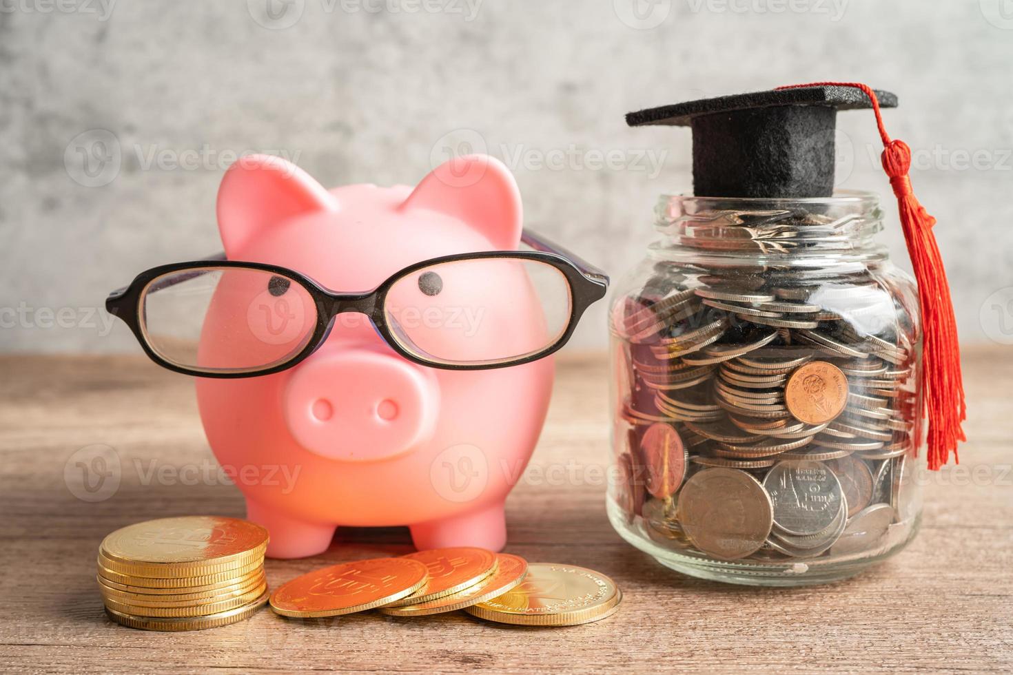 varkenspesten bank vervelend lenzenvloeistof met munten en diploma uitreiking hoed besparing bank onderwijs concept. foto