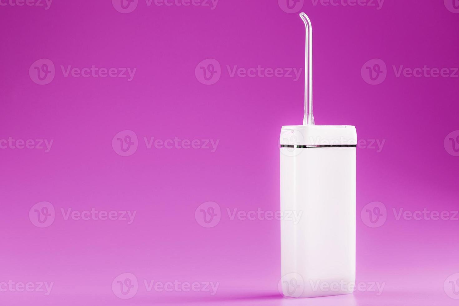 een irrigator voor poetsen tanden Aan een roze achtergrond. foto