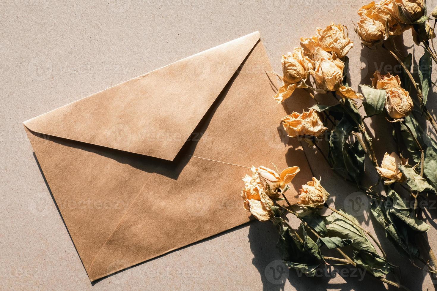 droog bloemen en bruin papier envelop, wijnoogst vlak leggen foto