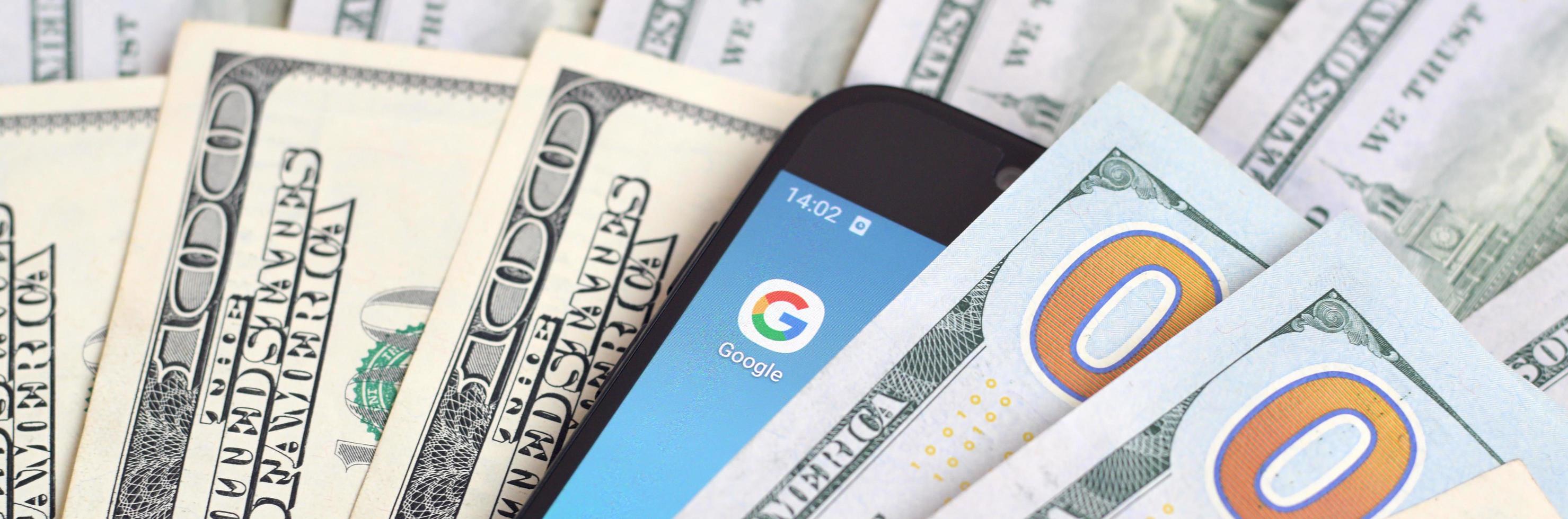 smartphone scherm met google app en veel van honderd dollar rekeningen. bedrijf en sociaal netwerken concept foto