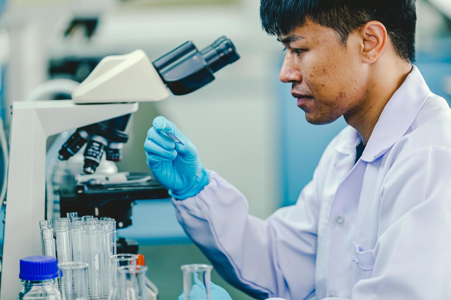 biochemie laboratorium Onderzoek, wetenschapper of medisch in laboratorium jas Holding test buis met gebruik makend van reagens met laten vallen van kleur vloeistof over- glas uitrusting werken Bij de laboratorium. foto