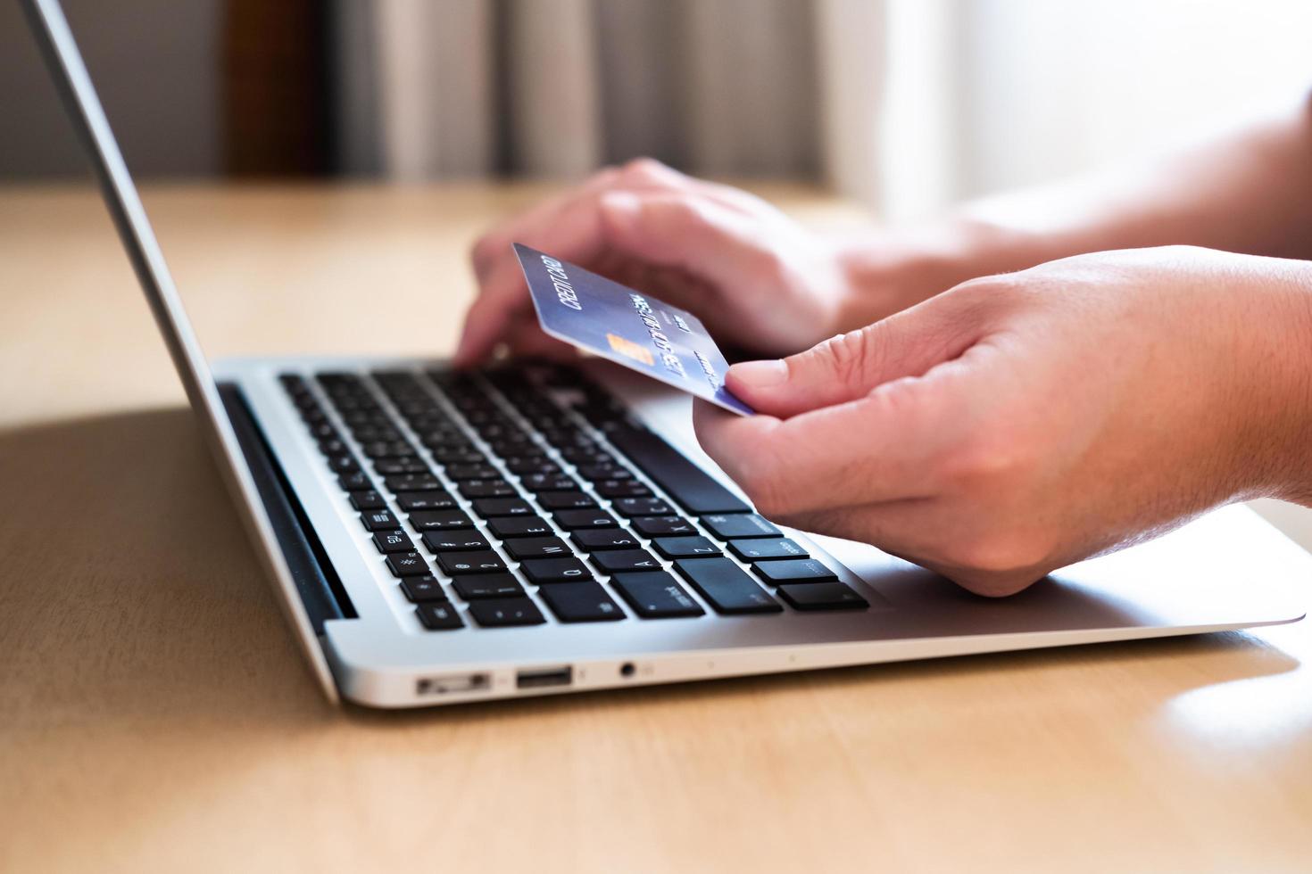 mannen hand met creditcard en typ betalingsinformatie op toetsenbord voor online winkelen bestellen. internettechnologie en digitale marktplaats e-commerce lifestyle concept, aankooptransactie. foto