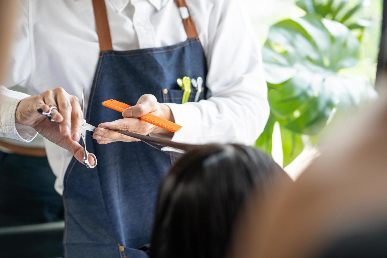 dichtbij omhoog schot Bij hand- van haar- elegant terwijl Doen haar- besnoeiing en haar- dressoir en behandeling terwijl styling haar- voor cliënt. professioneel bezigheid, schoonheid en mode onderhoud bezigheid. foto