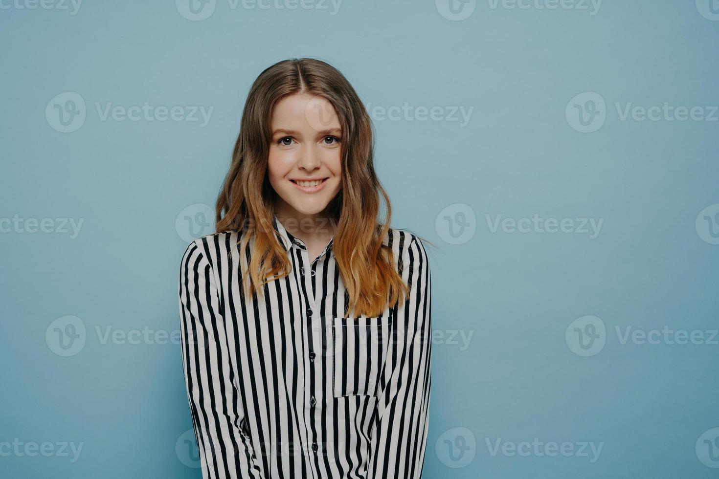 schattig gelukkig tienermeisje in gestreept shirt dat positieve emoties uitdrukt foto