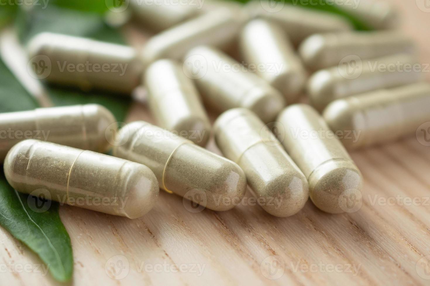 kruiden geneeskunde capsules met andrographis paniculata blad Aan hout tafel foto