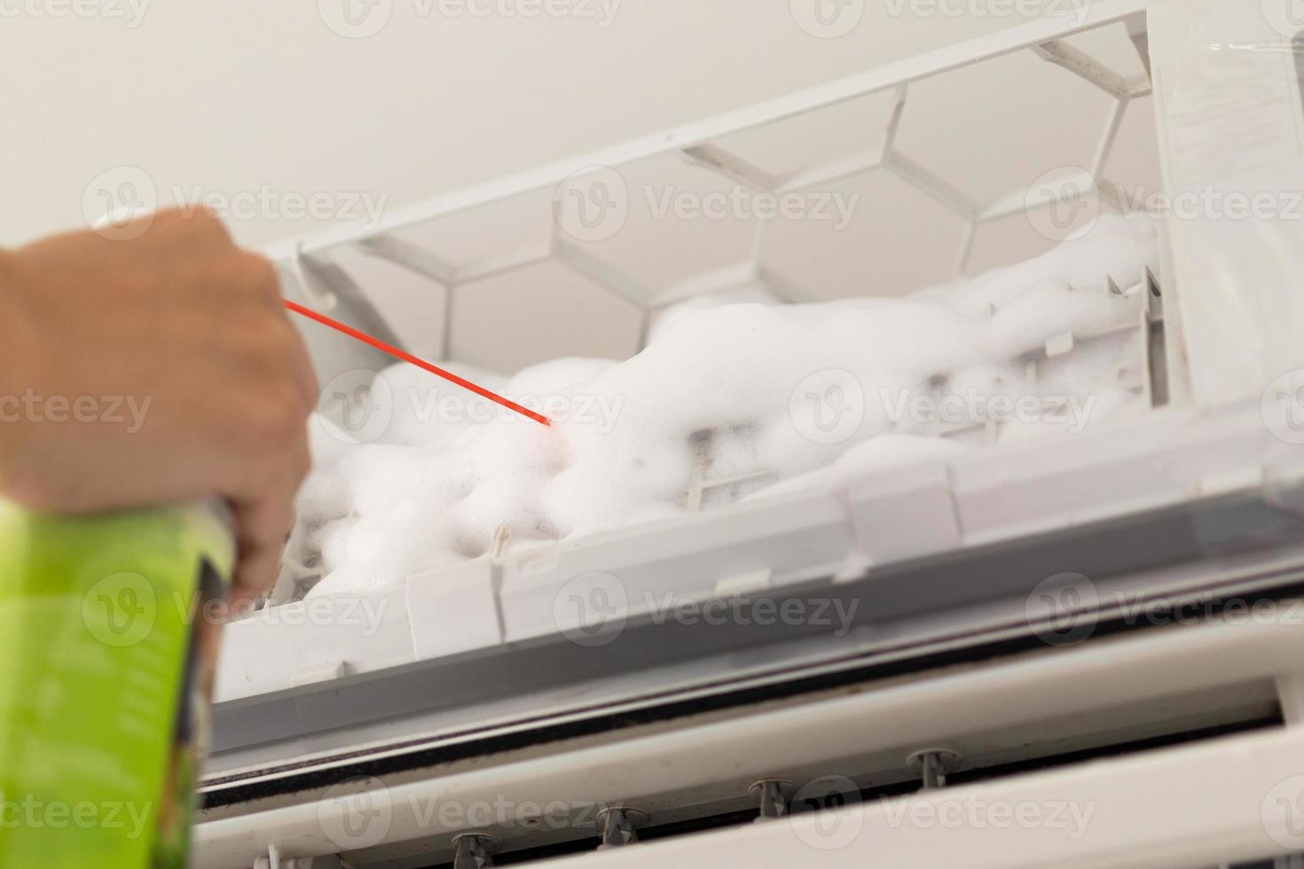 lucht conditioner schoonmaak met verstuiven schuim schoonmaakster foto