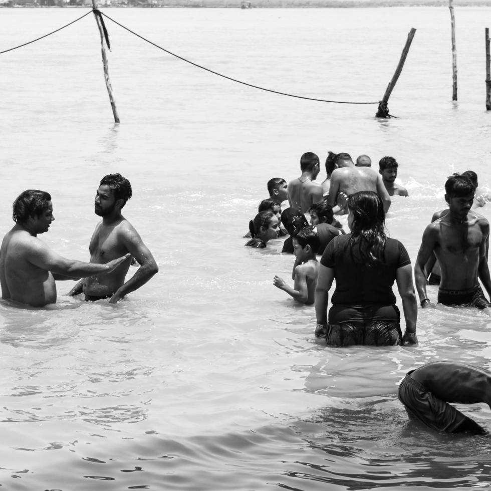 garh mukteshwar, up, india, 11 juni 2022 -mensen nemen een heilige duik ter gelegenheid van nirjala ekadashi, een uitzicht op garh ganga brij ghat, een zeer beroemde religieuze plaats voor hindoes - zwart en wit foto
