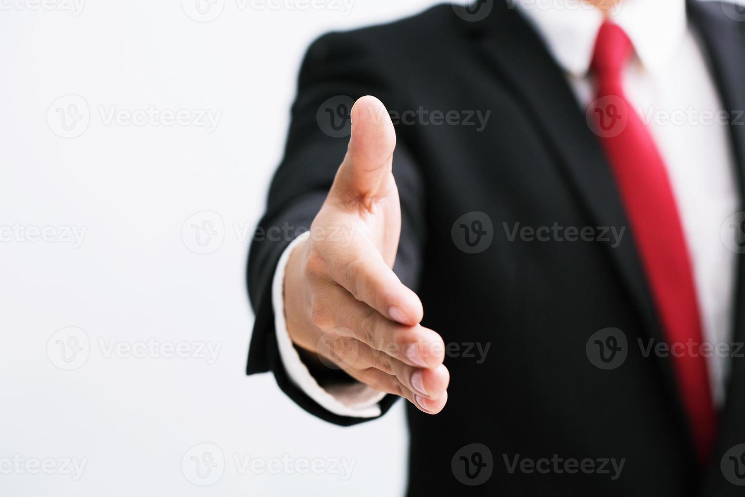 bedrijf Mens in pak en rood stropdas Open hand- klaar naar zegel een overeenkomst, houden uit die van jou hand- partner schudden handen, kopiëren ruimte. wit achtergrond. foto