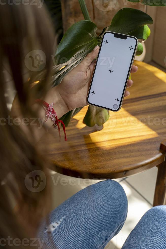 jong latina vrouw Aan haar cel telefoon, verschillend activiteiten, wit scherm, mockup of groen scherm foto