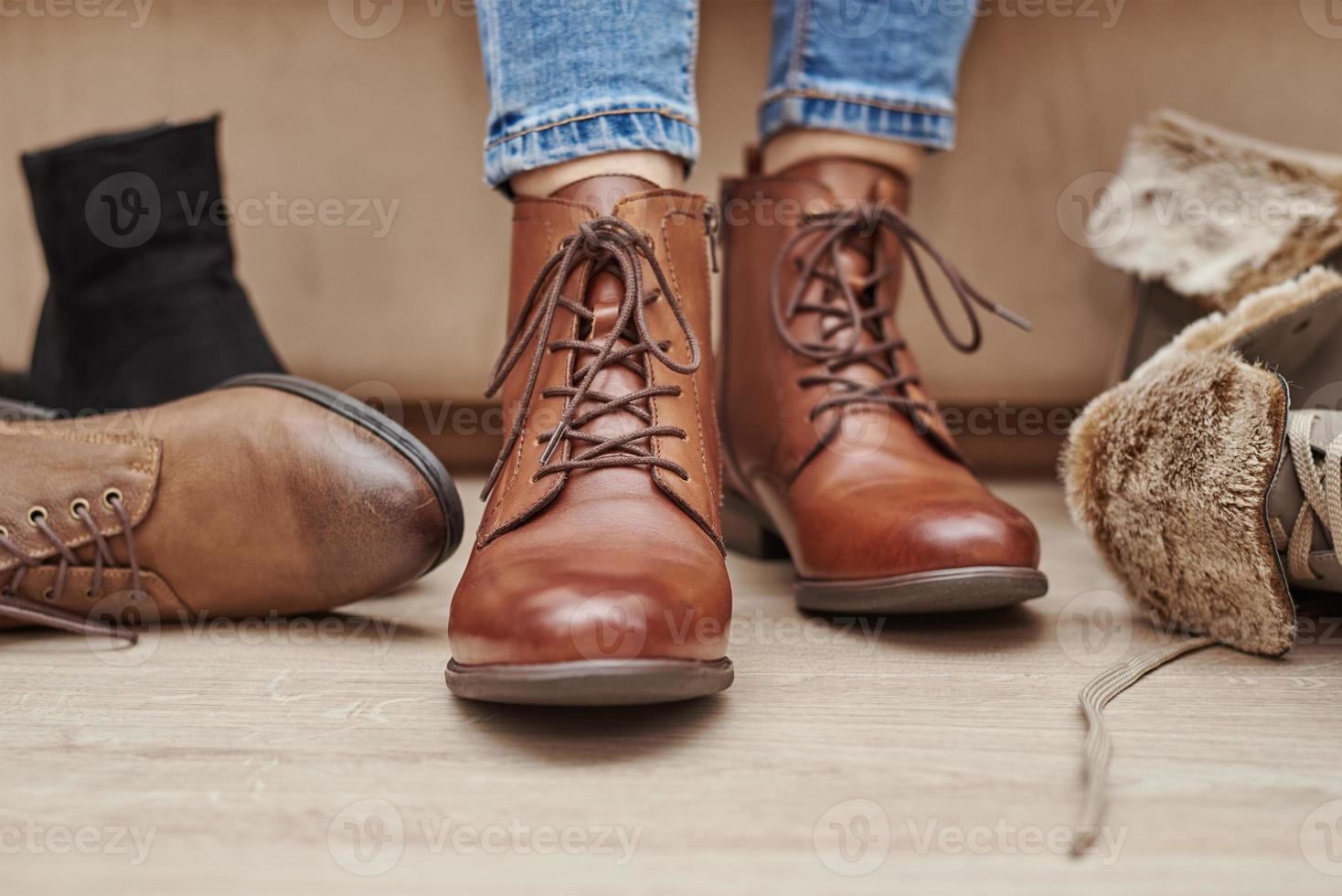 vrouw kiest comfortabel bruin leer schoenen tussen bundel van de verschillend paren foto