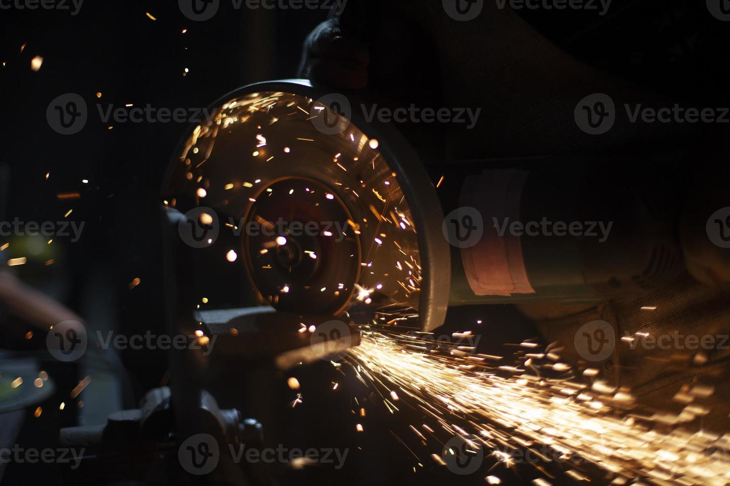 zagen staal. werk van zag Aan metaal. snijdend van staal profiel. vonken in donker. meester creëert ontwerp. foto