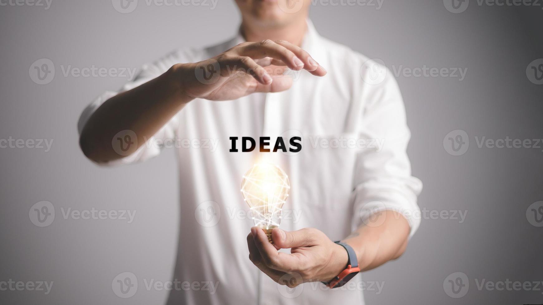 mannetje hand- Holding verlichte licht lamp, nieuw idee, innovatie en inspiratie concept, en ideeën woord foto