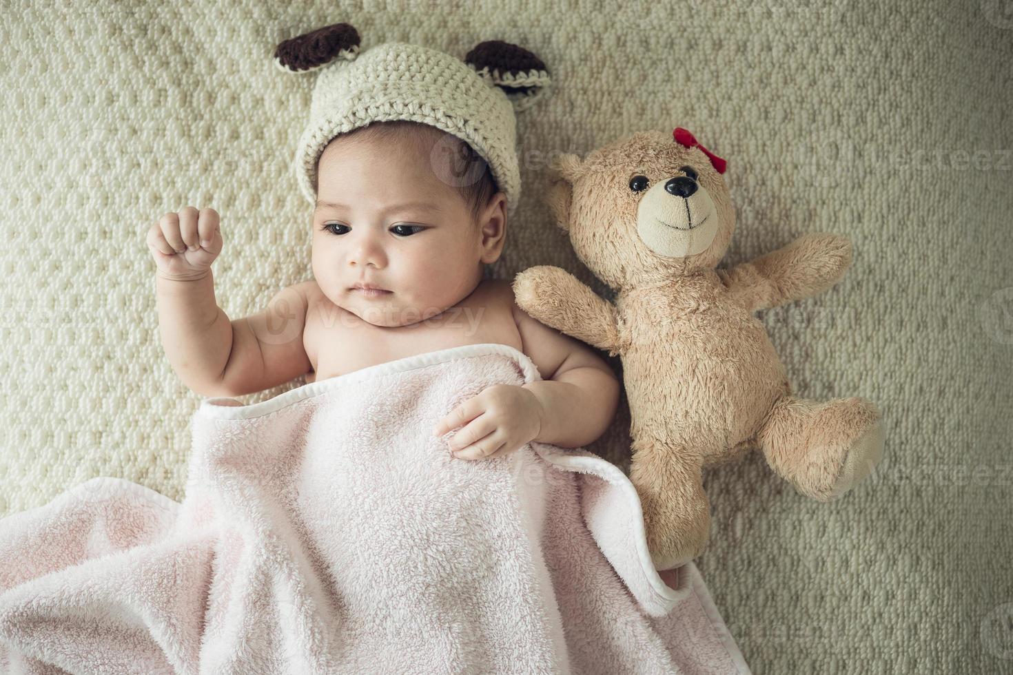 pasgeboren baby Aan een deken met een teddy foto