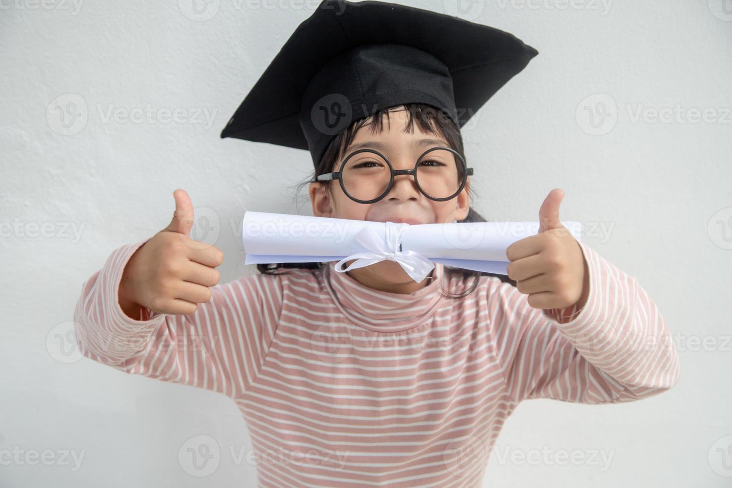 gelukkig Aziatisch school- kind afstuderen in diploma uitreiking pet foto