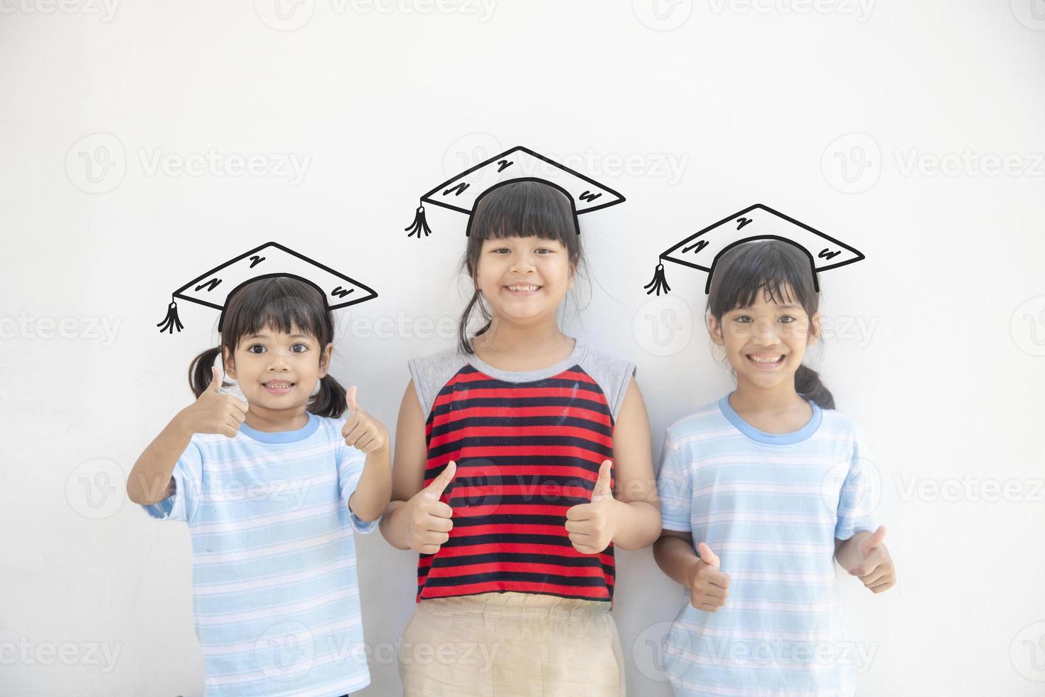 groep van gelukkig Aziatisch school- kind afstuderen in diploma uitreiking pet foto