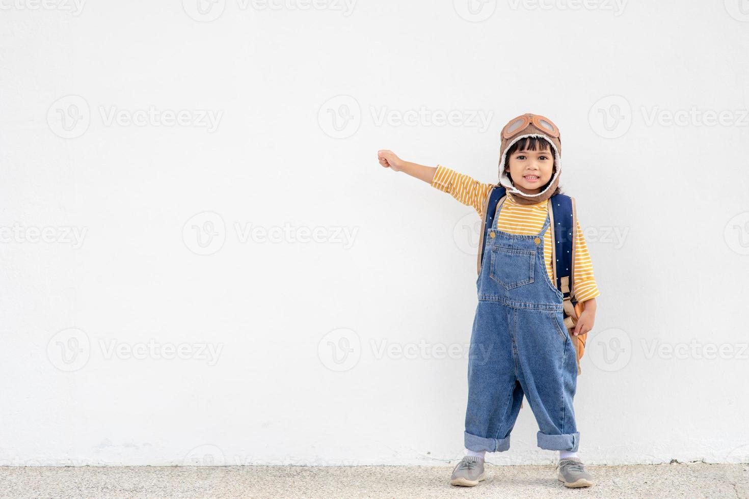 een schattig weinig meisje gekleed in een pet en bril van een piloot. de kind dromen van worden een piloot. foto