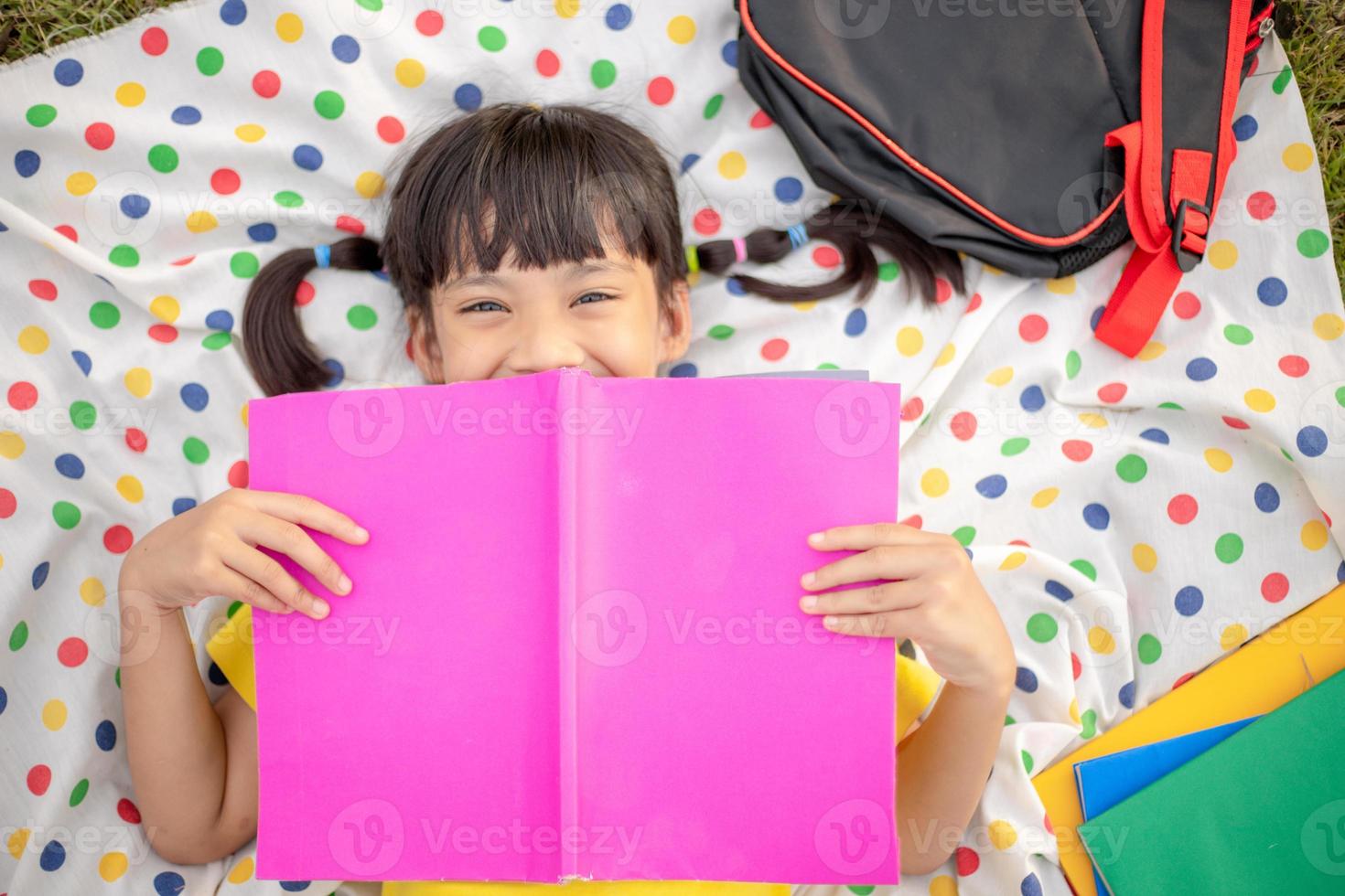 Aziatisch jong meisje lezen een boek ,aan het leren vaardigheden concept. foto