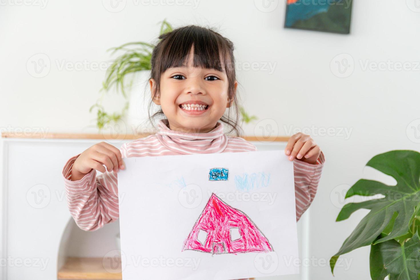 weinig peuter- meisje weergeven haar afbeelding trots foto