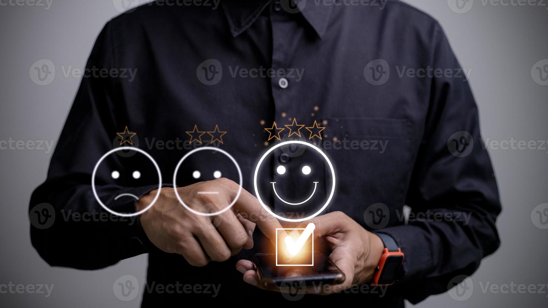 klant onderhoud evaluatie concept. gebruik makend van een smartphone is drukken gezicht emoticon glimlachen in tevredenheid Aan virtueel tintje scherm. foto