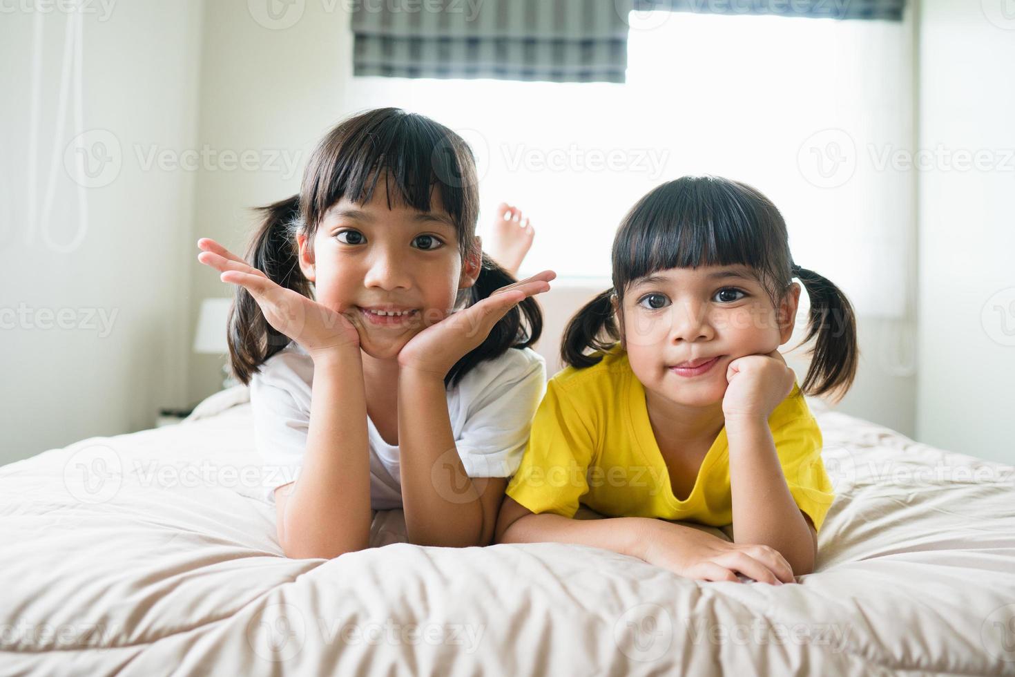 schattig Aziatisch kinderen aan het liegen Aan de bed foto