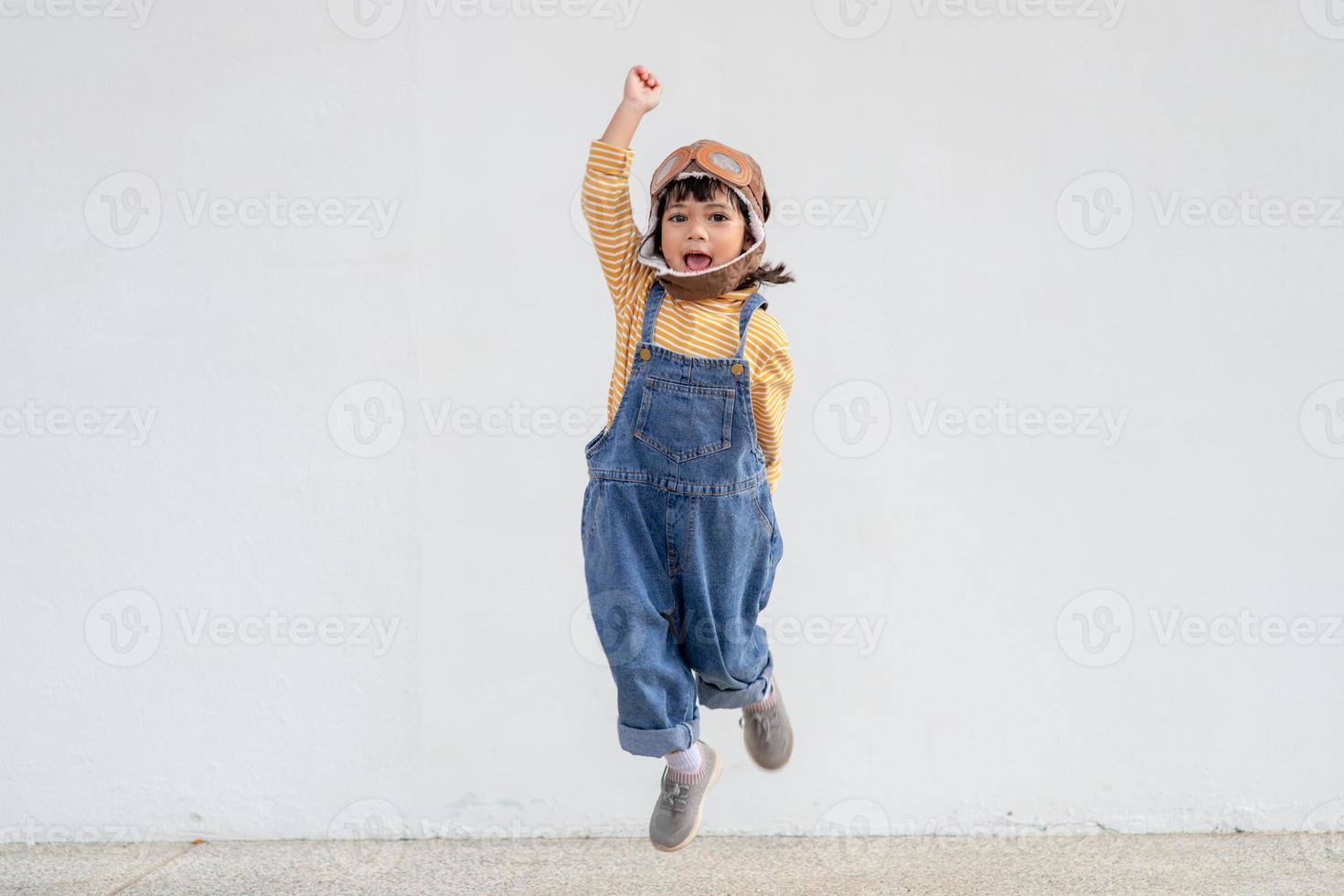 dromen van vlucht weinig kind meisje spelen met een piloot hoed Aan wit achtergrond foto